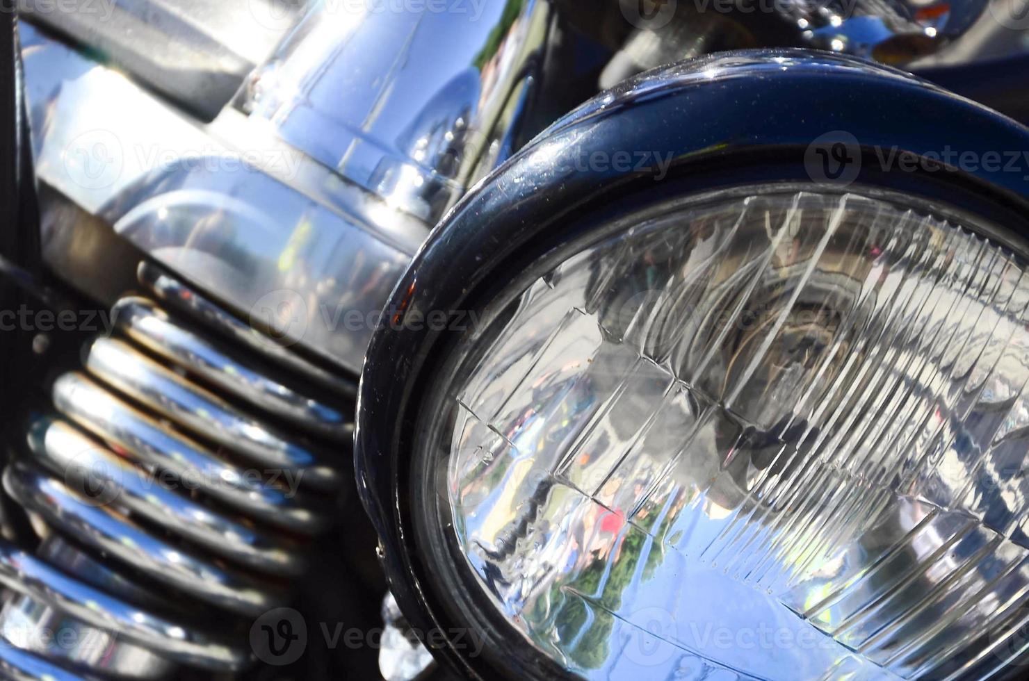 Fragment of chromed shiny lamp of old classic motorbike photo