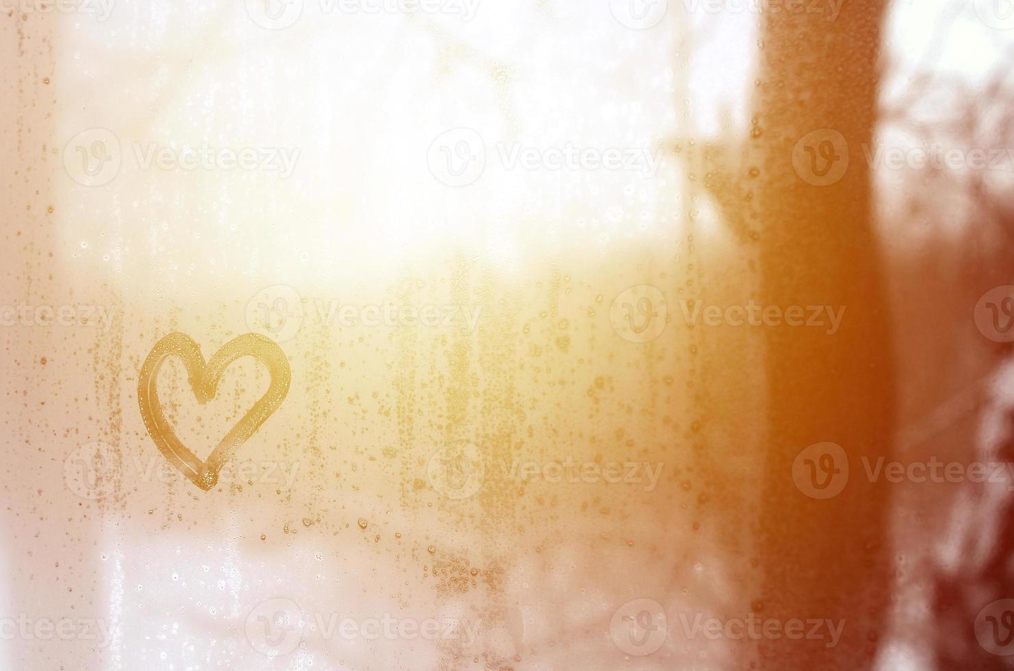 The heart is painted on the misted glass in the winter photo