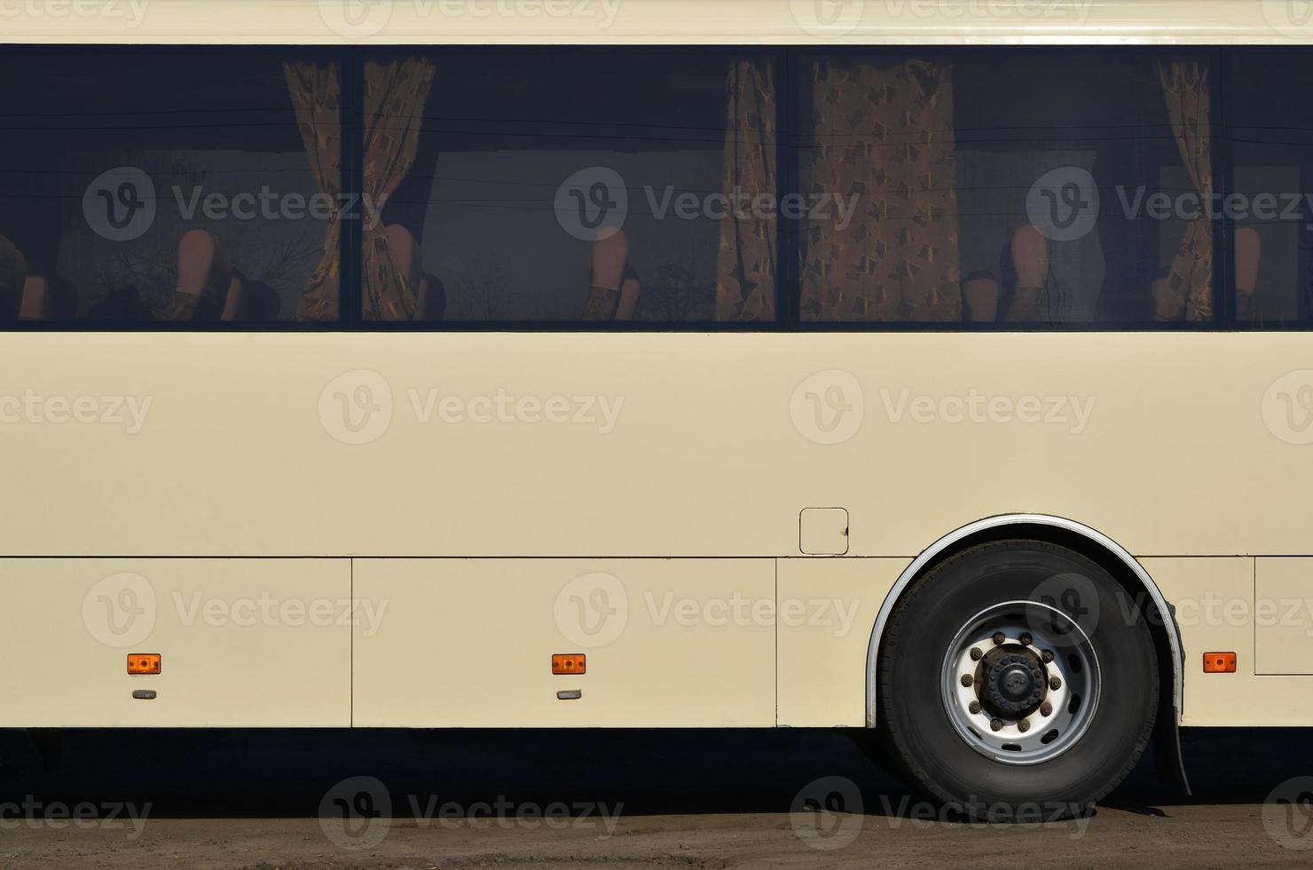 Photo of the hull of a large and long yellow bus with free space for advertising. Close-up side view of a passenger vehicle for transportation and tourism