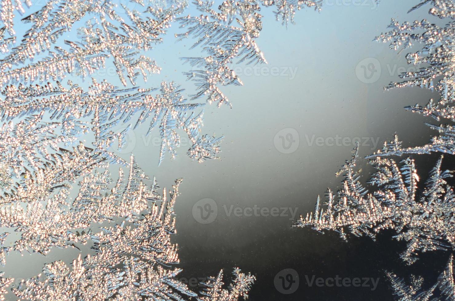 Snowflakes frost rime macro on window glass pane photo