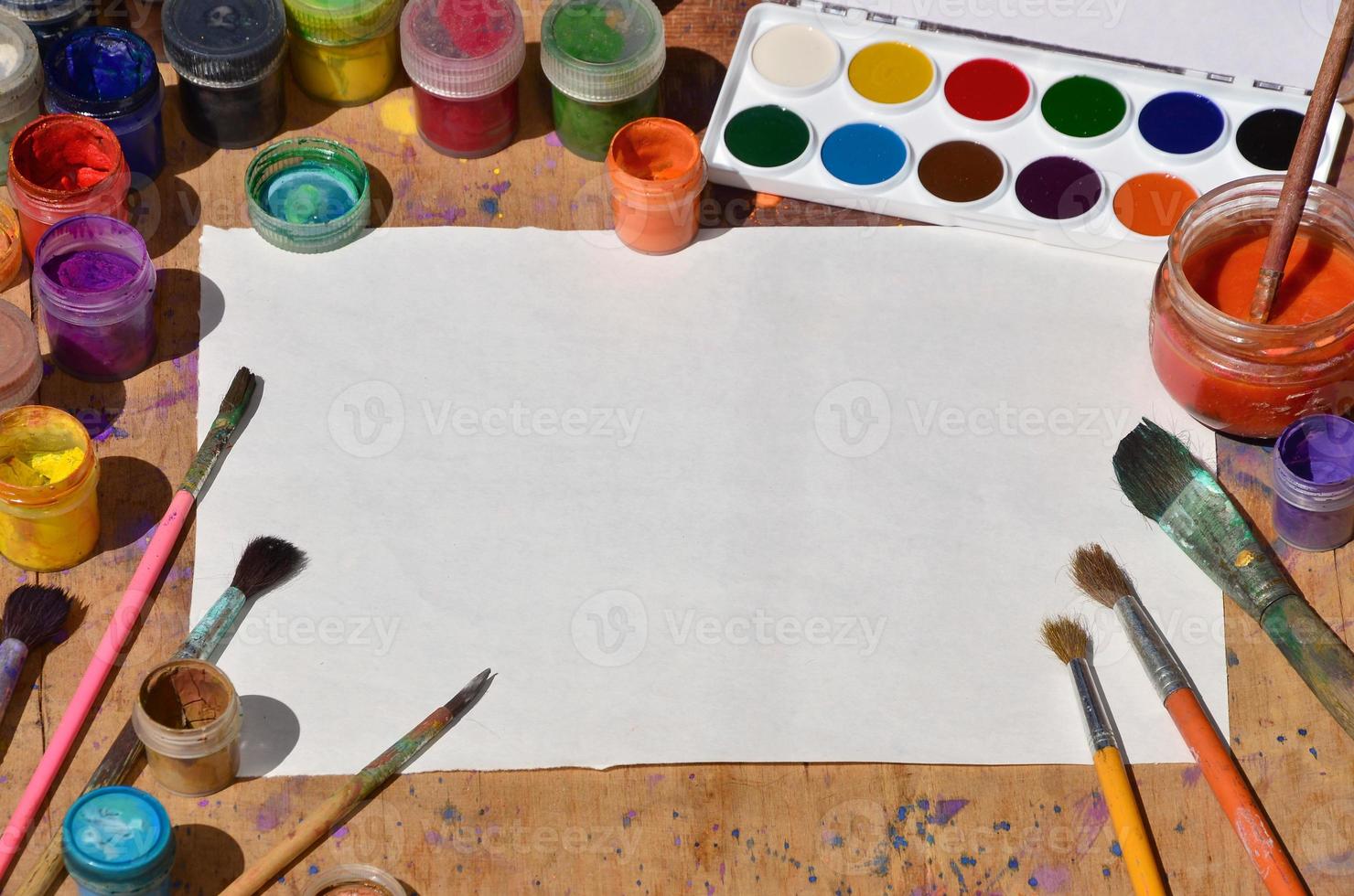 Still life with blank paper, brushes and jars of watercolor and gouache paint photo
