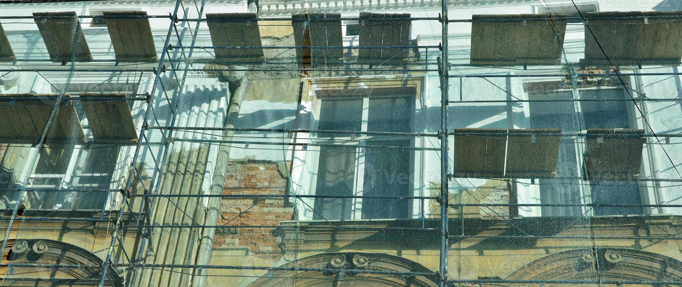 The old building is under reconstruction. Scaffolds installed and protected by a strong mesh photo