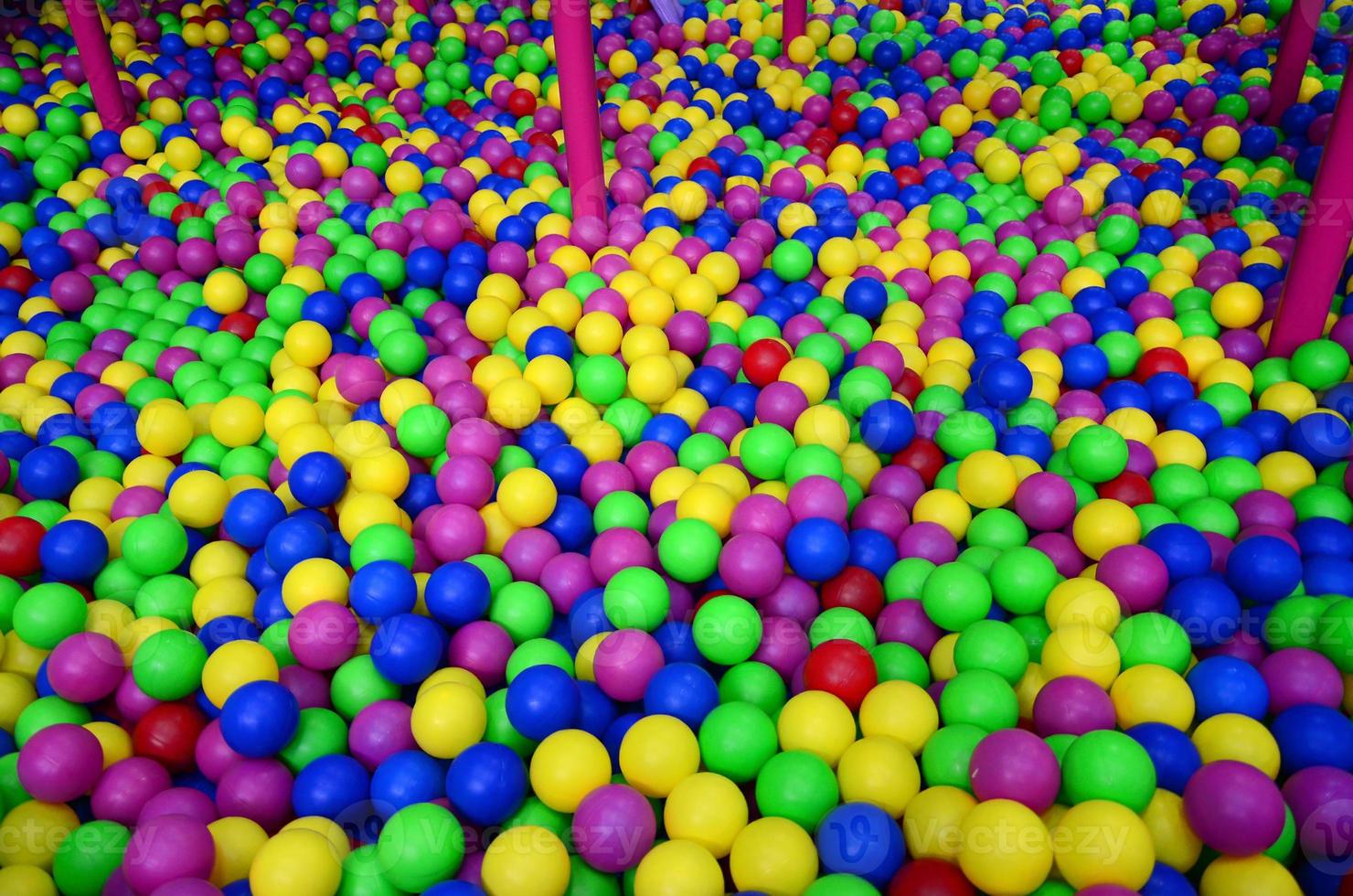 Many colorful plastic balls in a kids' ballpit at a playground. Close up pattern photo