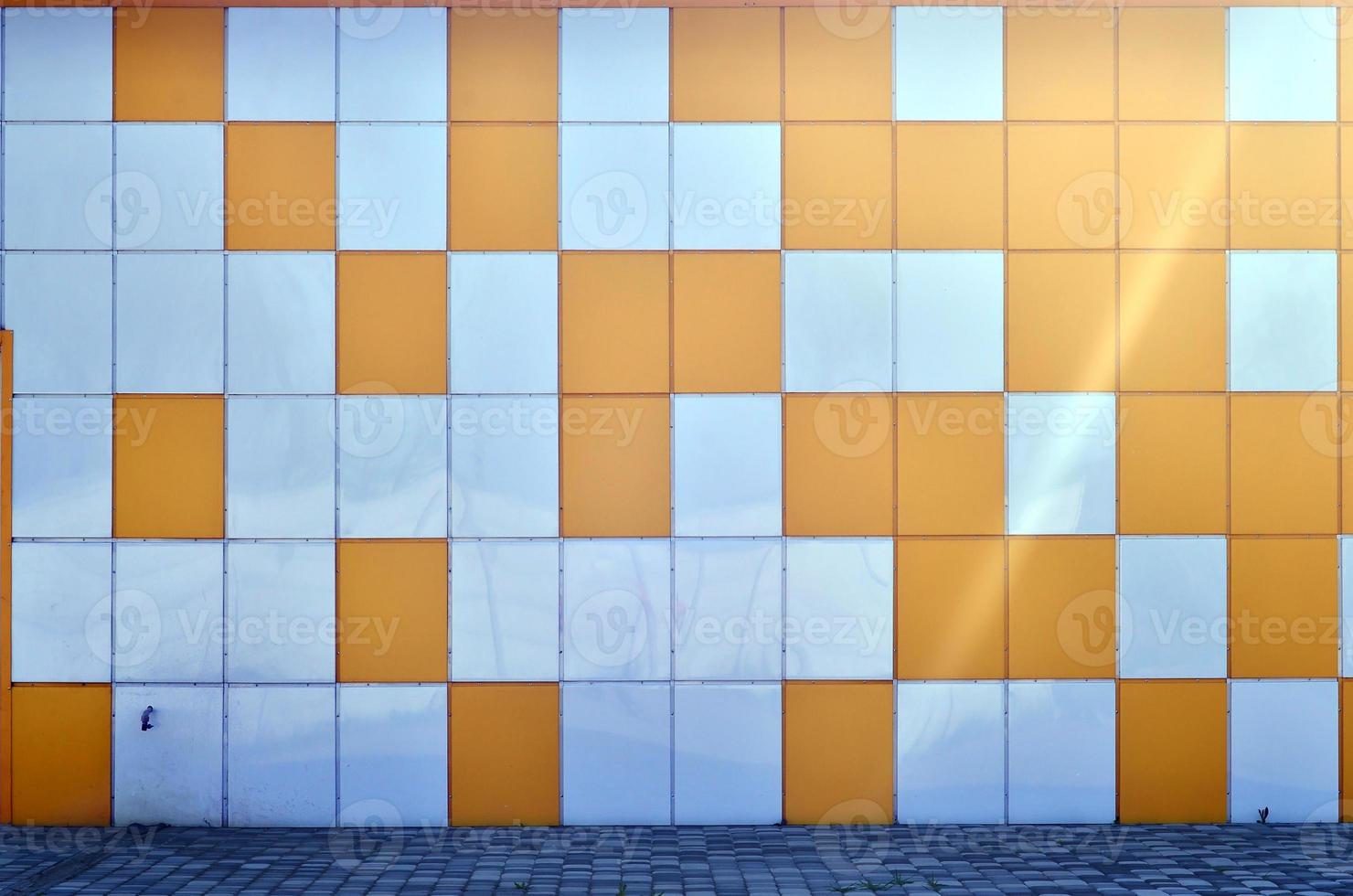 The texture of the metal wall, framed in the form of colored squares of two colors. Modern wall design for the exterior of residential and office buildings photo