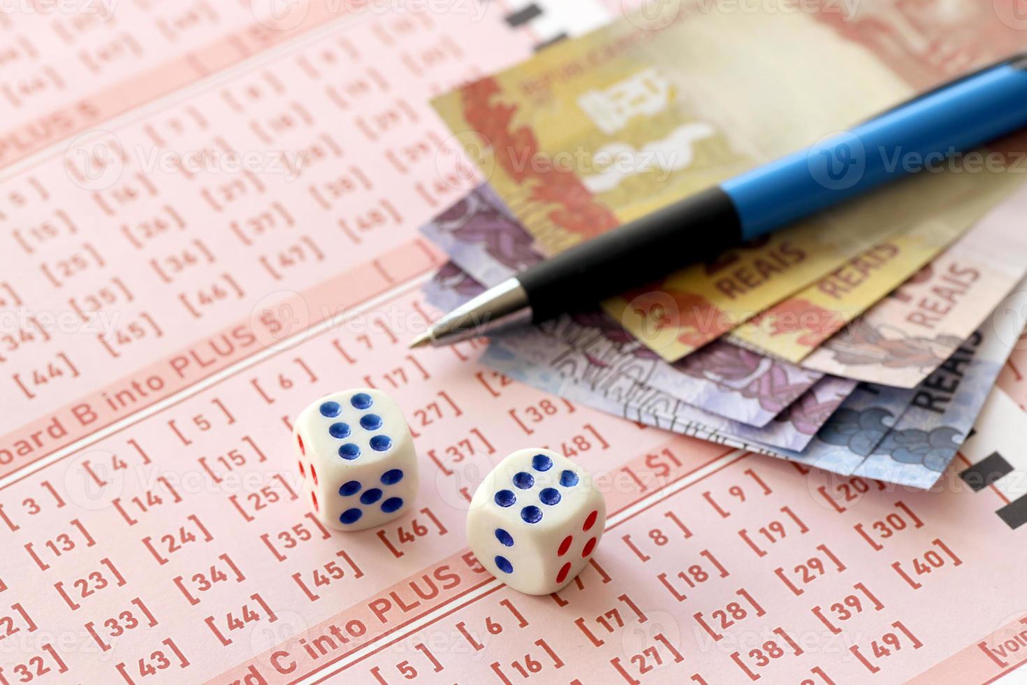 Dice cubes with Brazilian money bills on blank of lottery game. Concept of luck and gambling in Brazil photo