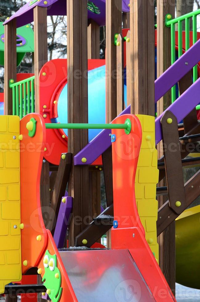 Fragment of a playground made of plastic and wood, painted in different colors photo