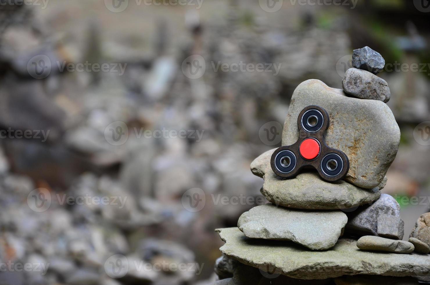 A wooden spinner lies on strange stone structures in the forest photo
