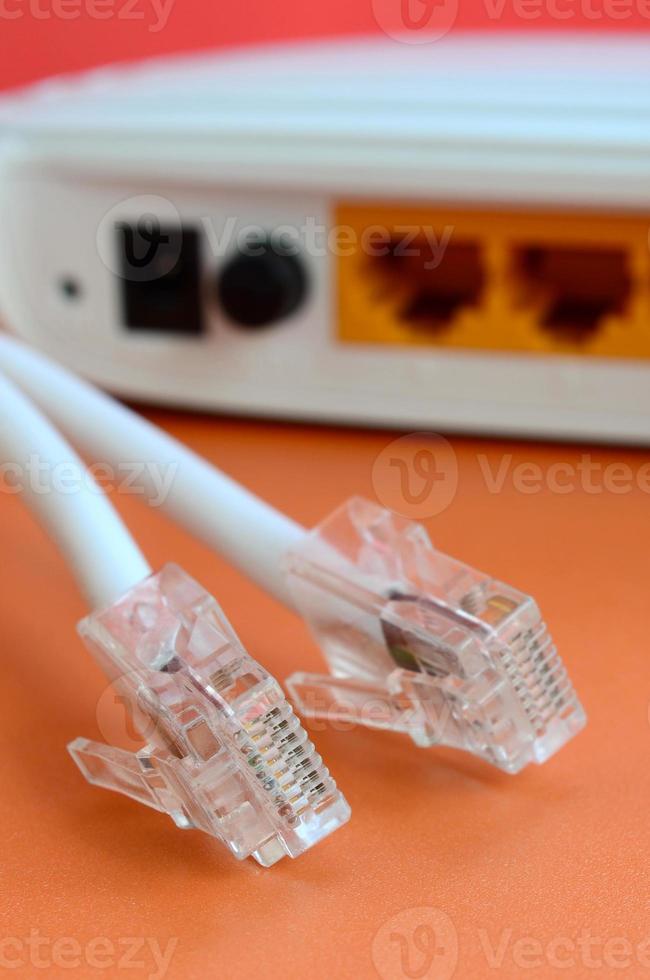 Internet router and Internet cable plugs lie on a bright orange background. Items required for Internet connection photo
