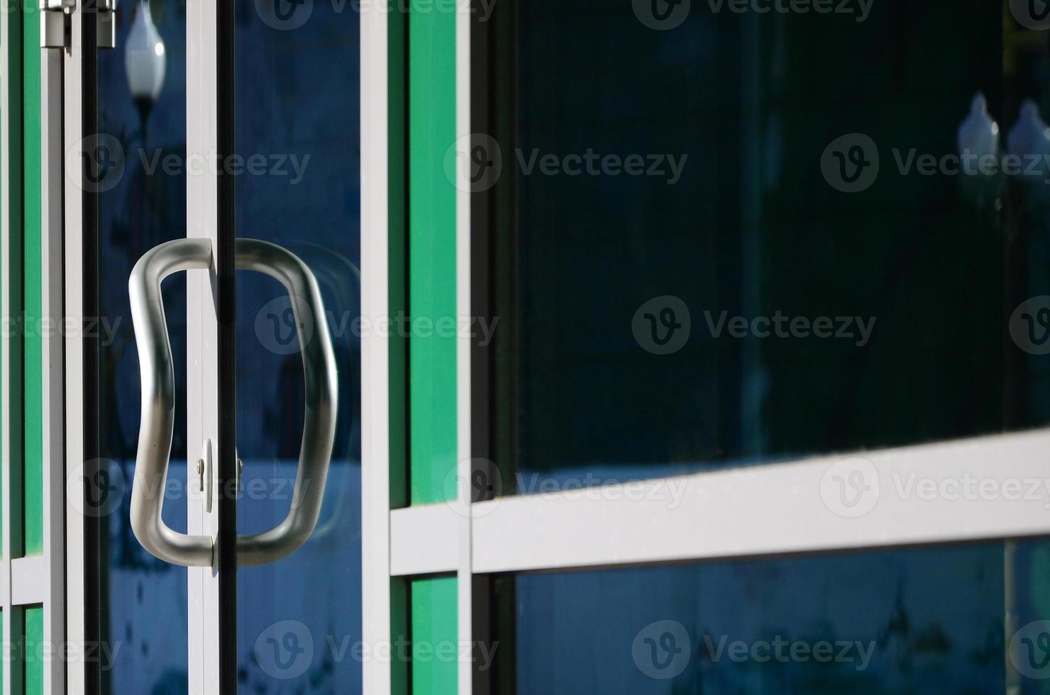 Chrome door handle and glass of modern aluminium office facade photo