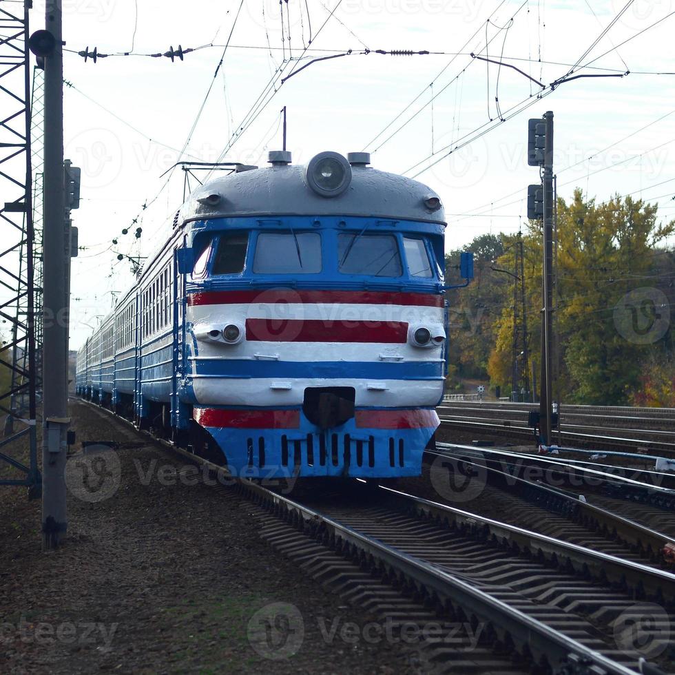 Old soviet electric train with outdated design moving by rail photo