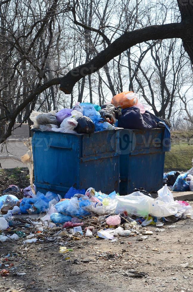 el bote de basura está lleno de basura y desechos. retiro intempestivo de basura en zonas pobladas foto