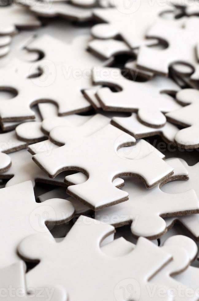 Close-up of a pile of uncompleted elements of a white puzzle. A huge number of rectangular pieces from one large white mosaic photo