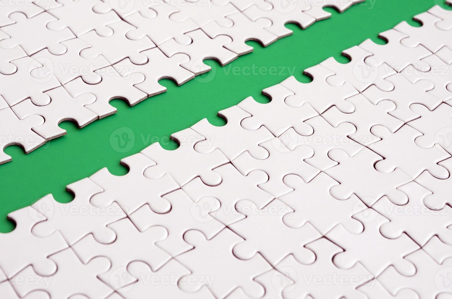 The green path is laid on the platform of a white folded jigsaw puzzle. Texture image with copy space for text photo