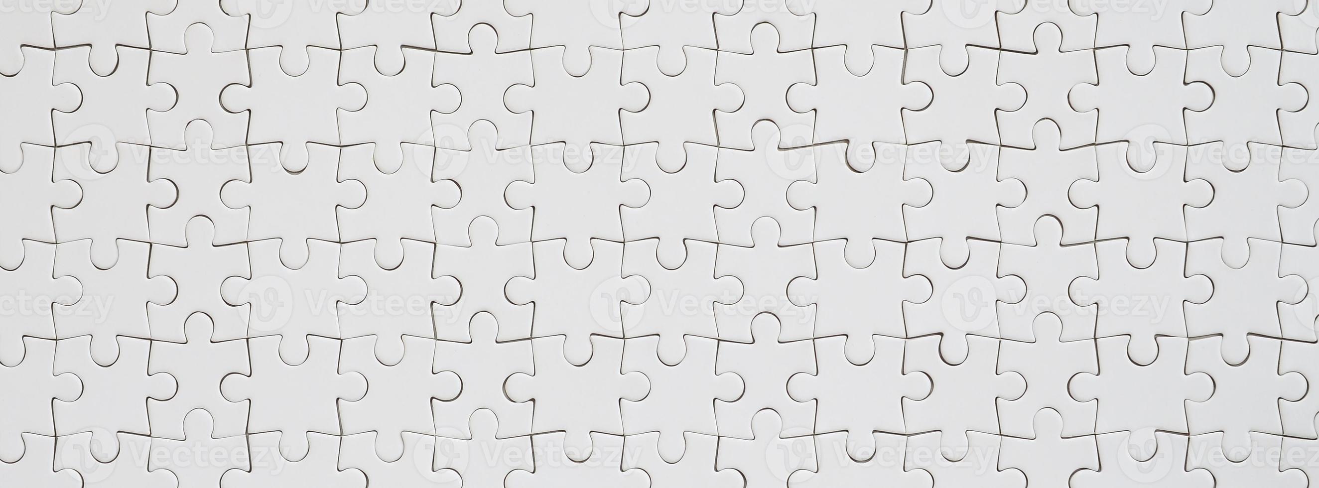Close up texture of a white jigsaw puzzle in assembled condition. Top view. Many components of a large whole mosaic are united photo