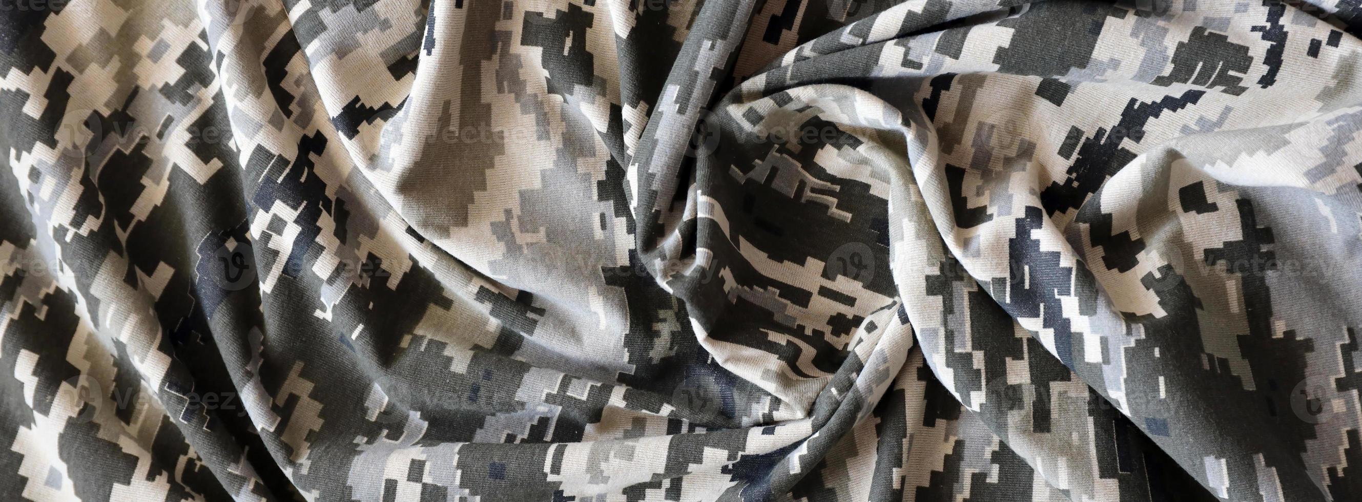 Fabric with texture of Ukrainian military pixeled camouflage. Cloth with camo pattern in grey, brown and green pixel shapes. Official uniform of Ukrainian soldiers photo