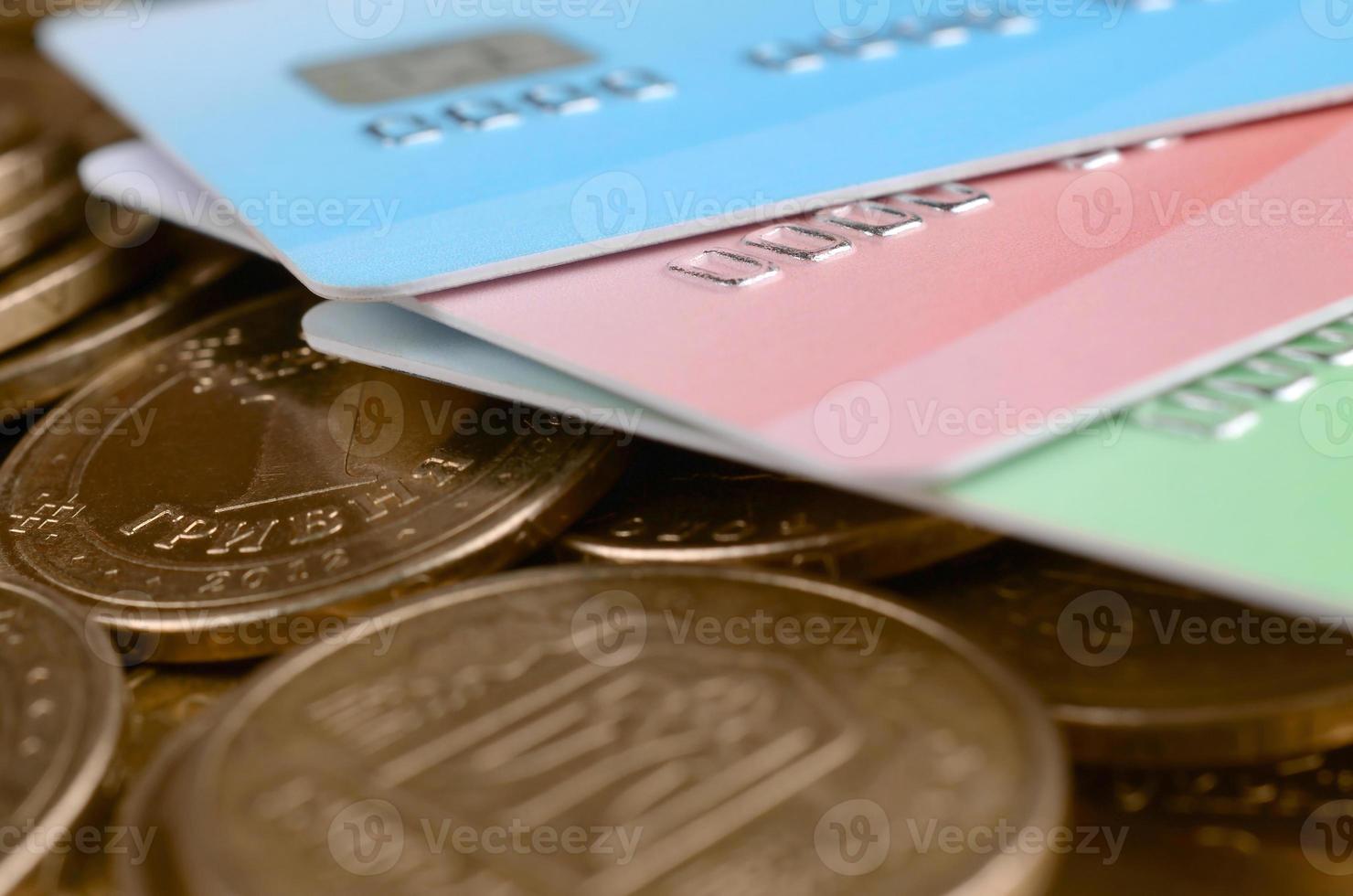 monedas de dinero ucranianas y tarjetas de crédito de colores de cerca foto