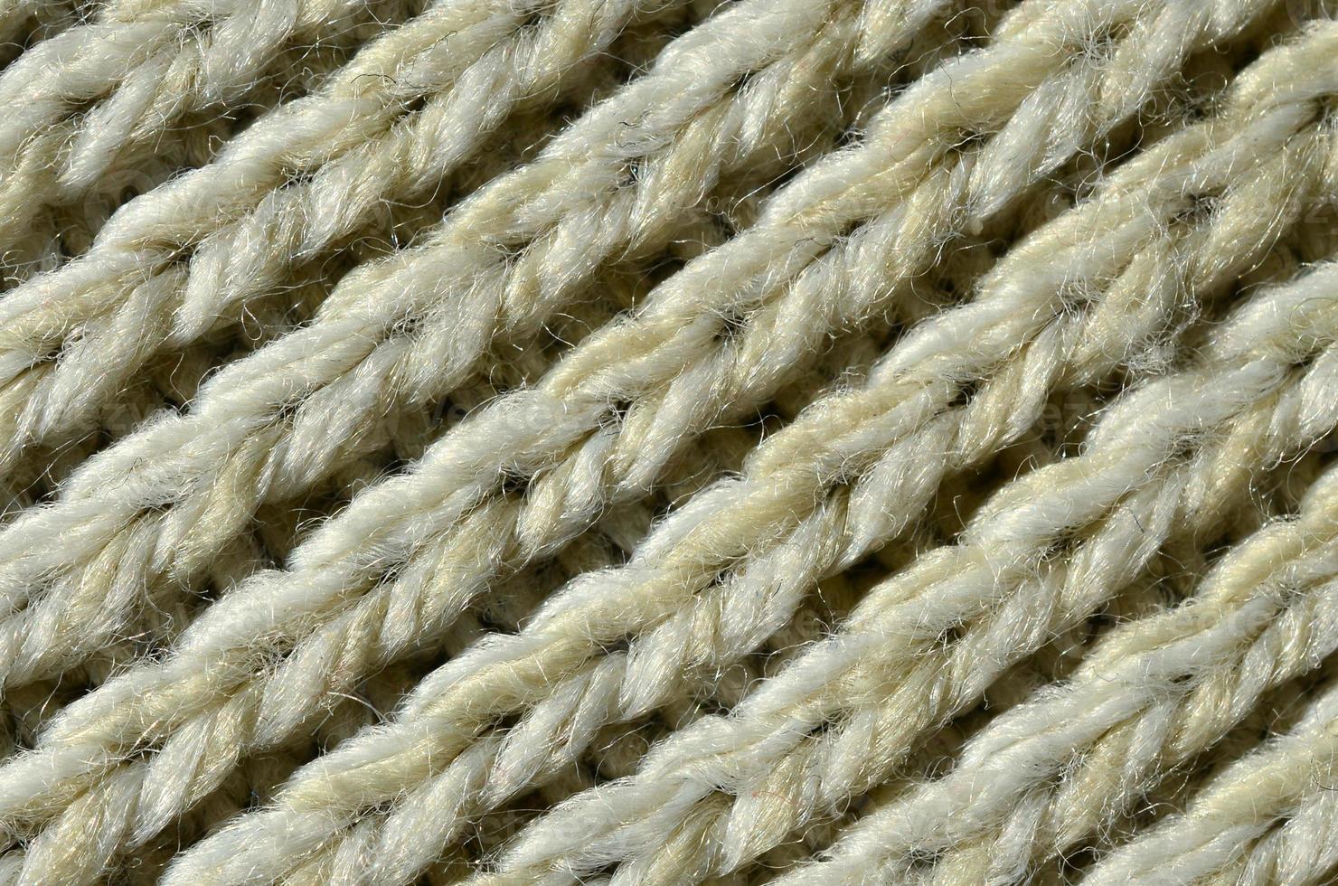 Fabric texture of a soft yellow knitted sweater. Macro image of the structure of bindings in yarns photo