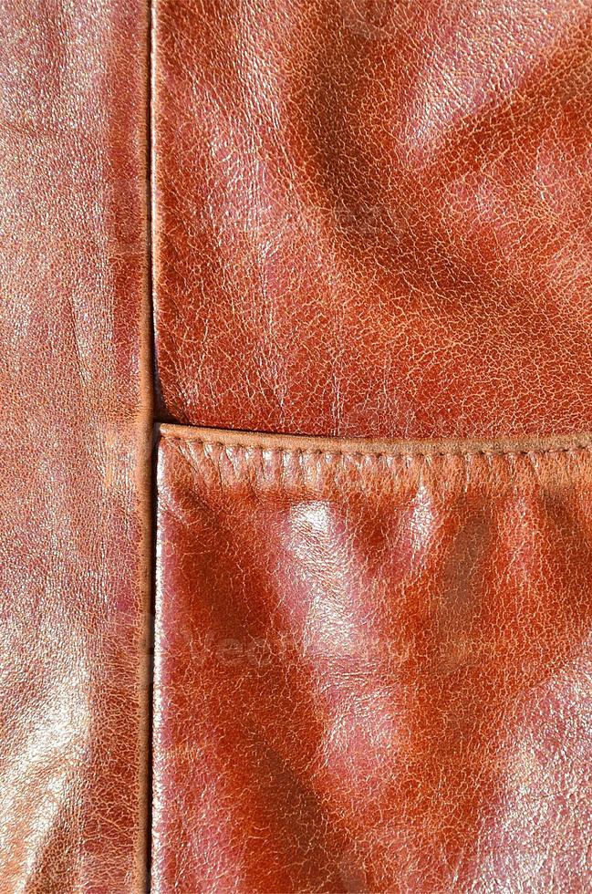 Brown leather texture. Useful as background for any design work. Macro photography of outerwear made of genuine leather photo