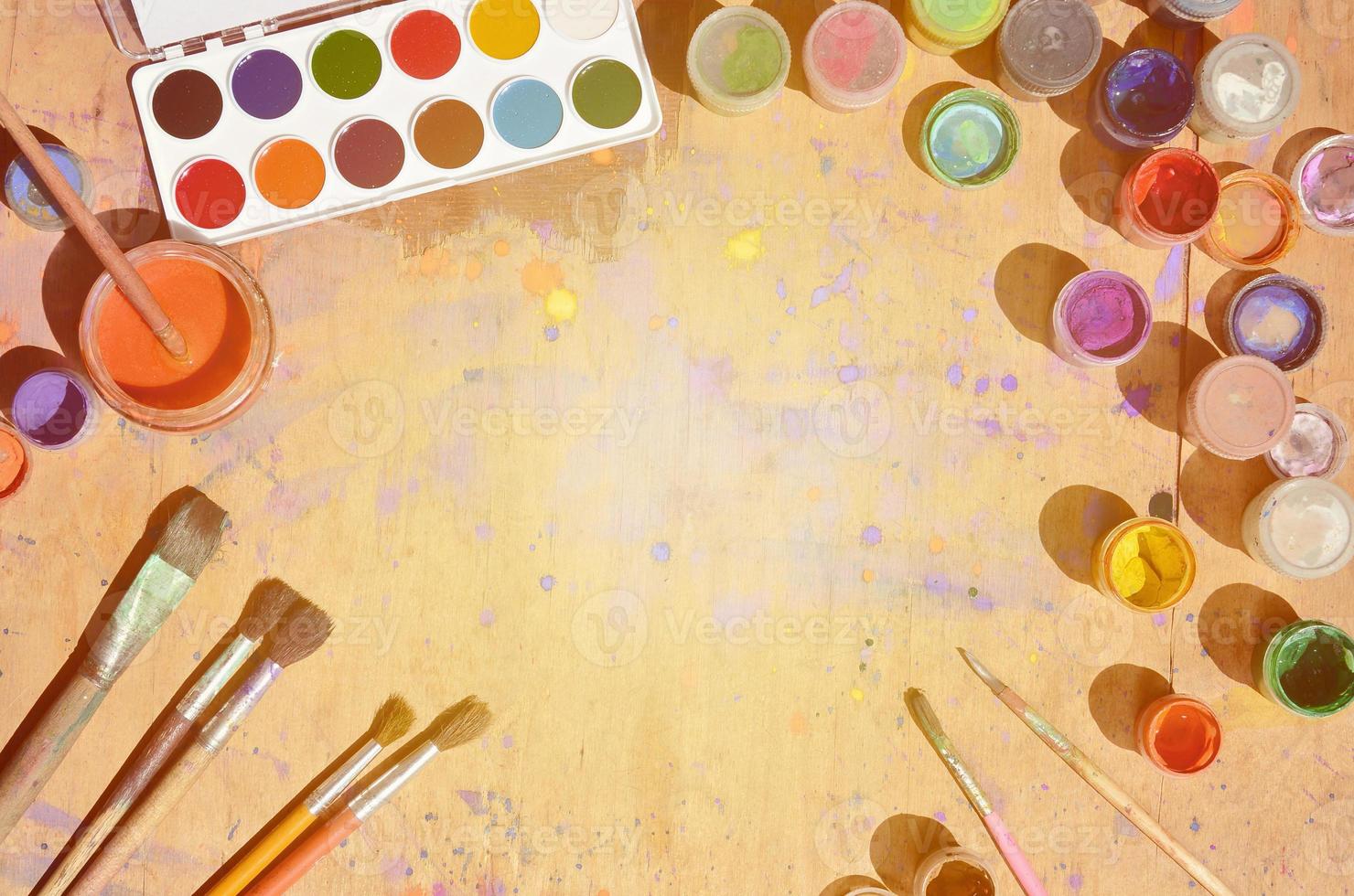 Still life with a lot of brushes and jars of watercolor and gouache paint photo