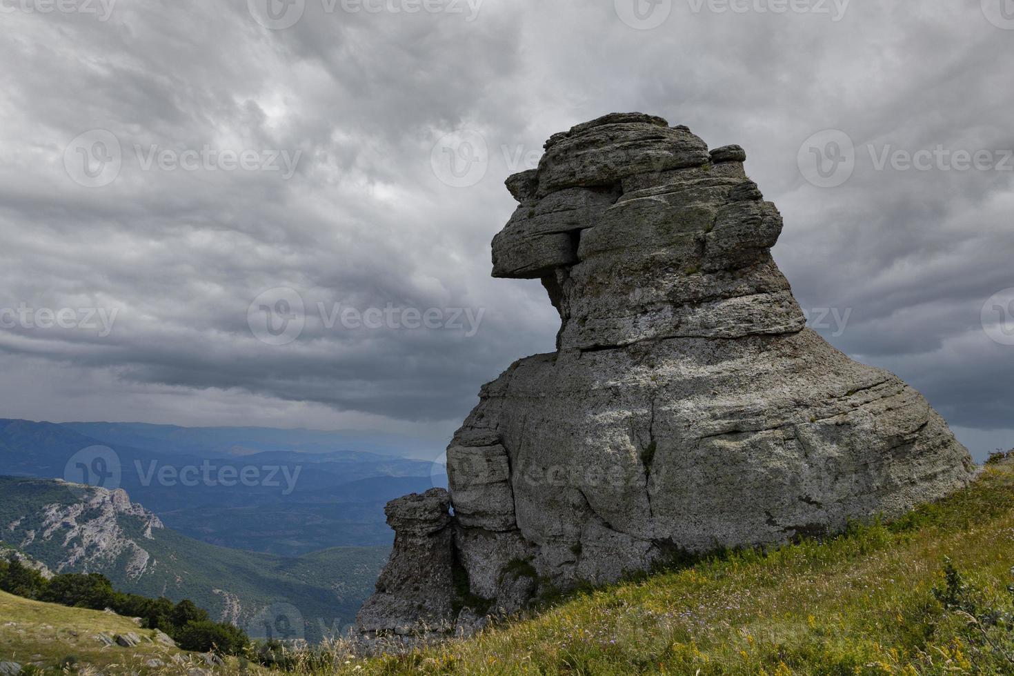 Mountain landscape, stone pillars in the form of ghosts, stone idols in a mountain valley, a canyon against the sky. photo