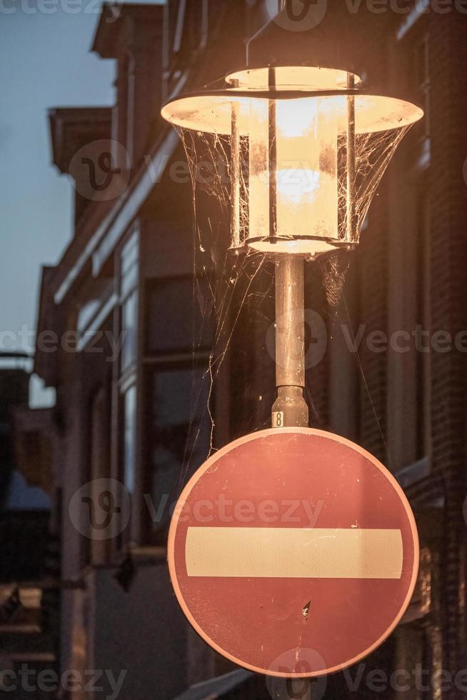 lámpara vieja con señal de tráfico en la noche foto