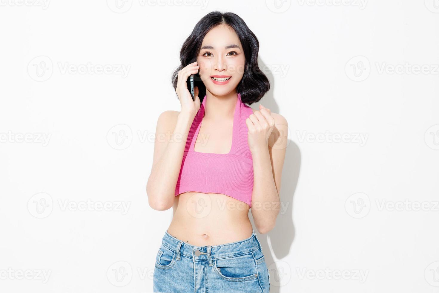 Fashionable asian woman short hair with Perfect body using mobile phone. Cute female model and sparkling eyes on white isolated background. Facial treatment, Cosmetology, beauty Concept. photo