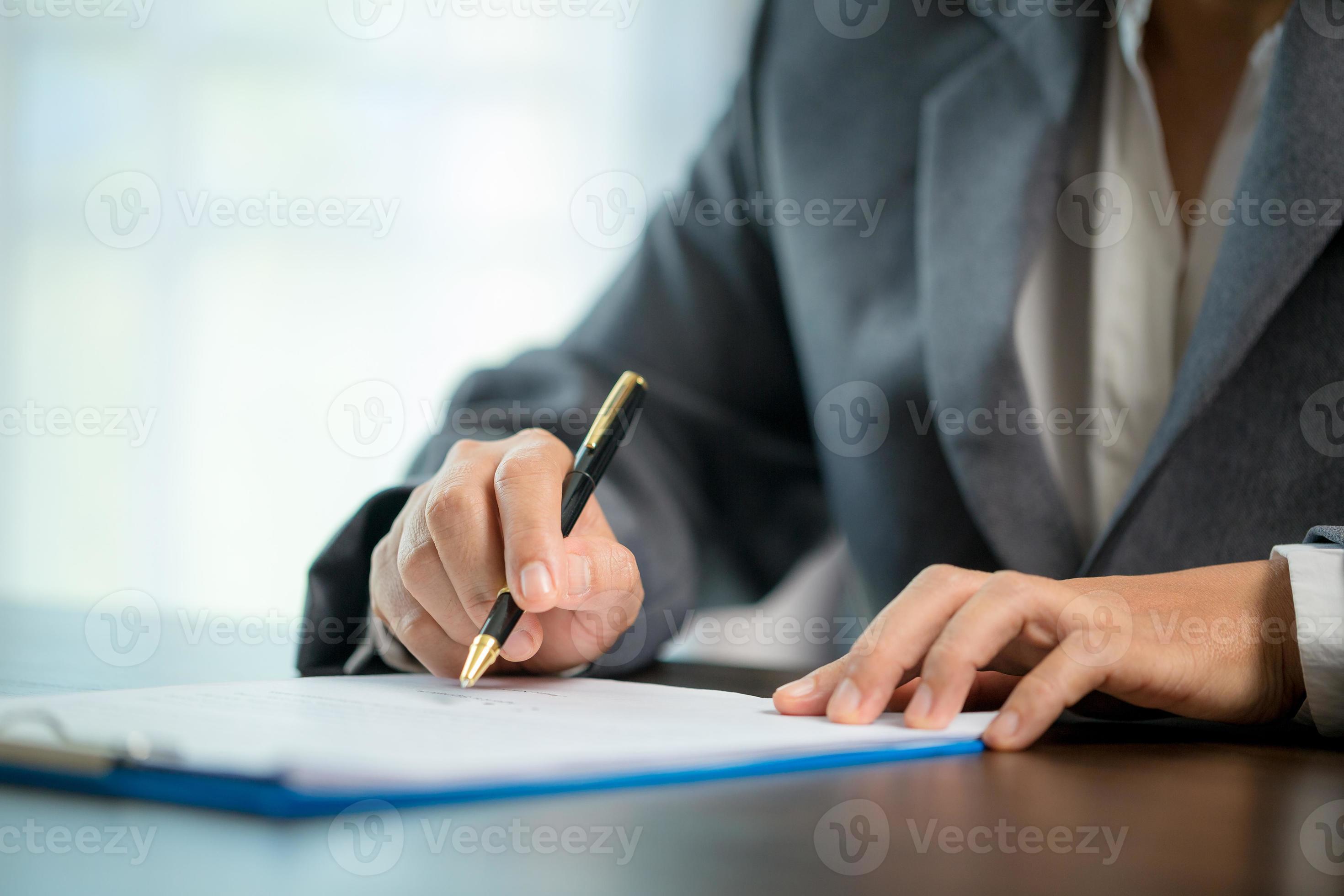 Workplace closeup person professional businesswoman sitting at desk hold pen signing or