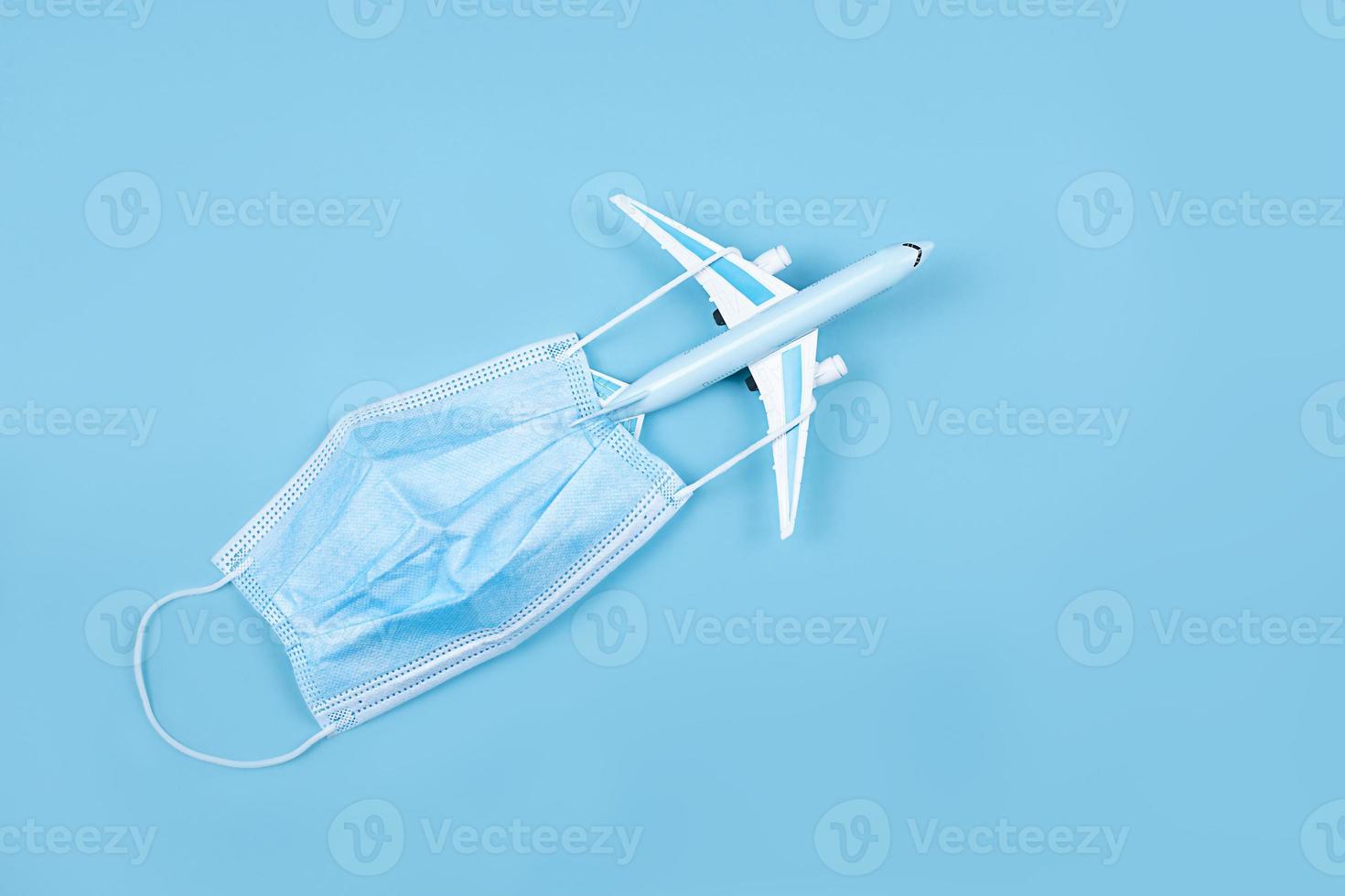 Airplane in flight with a medical mask. Concept - observance of safety on the plane. Traveling by air at social distance. Compliance with the recommendations of doctors on trips. Opening borders. photo
