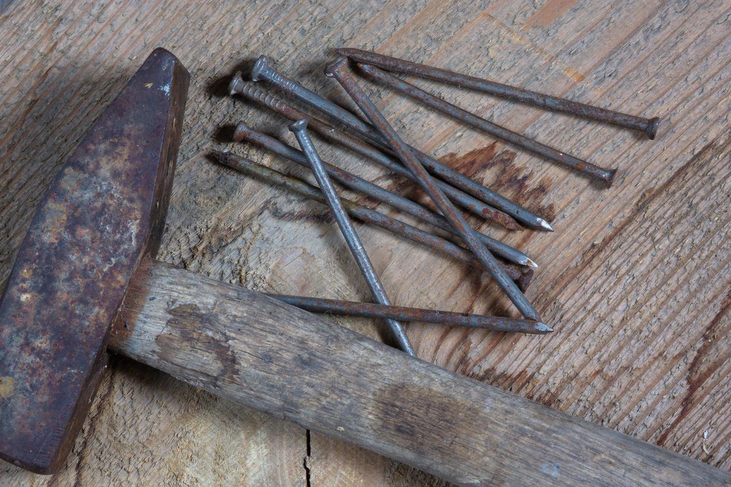 Different tools on a wooden background. Nails and a hammer photo