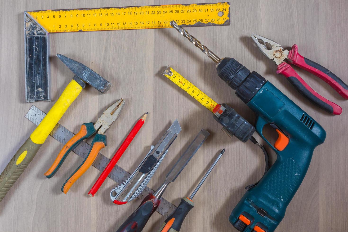 Different tools on a wooden background. Hammer, drill, pliers. Screwdriver, ruler, cutting pliers photo