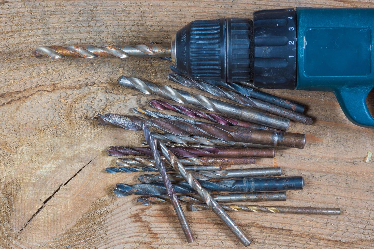 Different tools on a wooden background. drill, Wood drill, concrete drill bit photo