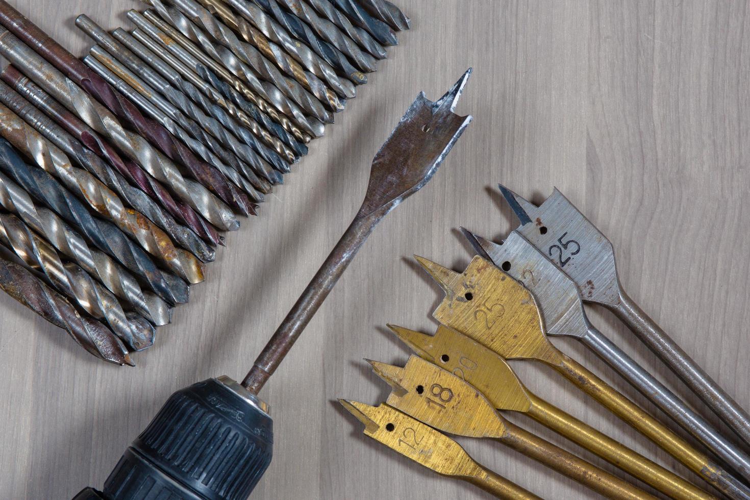 Different tools on a wooden background. drill, Wood drill, concrete drill bit photo