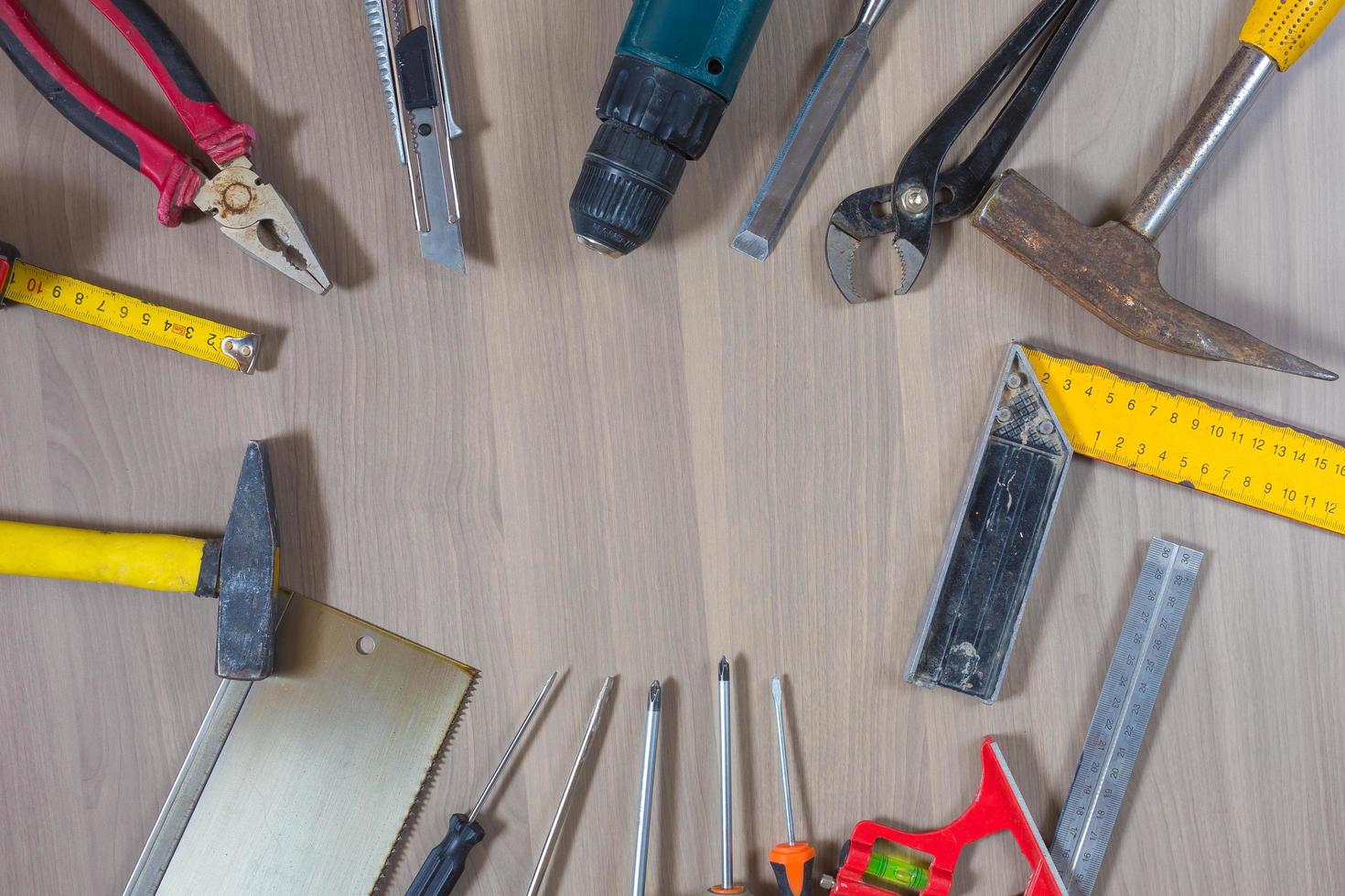 Different tools on a wooden background. Hammer, drill, pliers. Screwdriver, ruler, cutting pliers photo