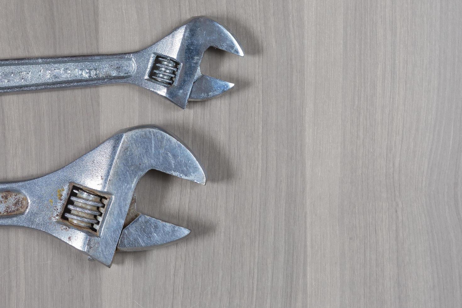 Different tools on a wooden background. Adjustable wrench photo