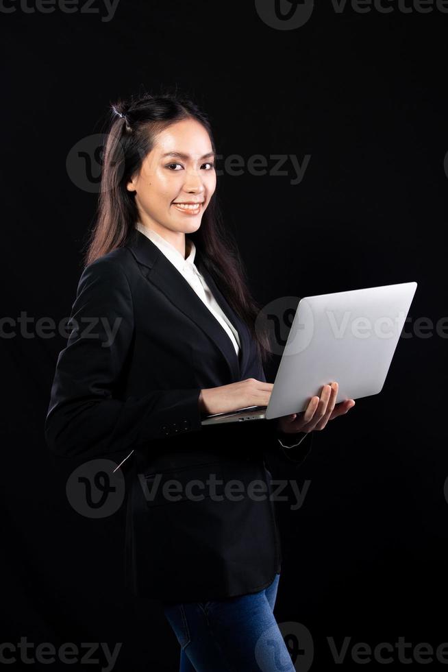 Business woman hold notebook computer and shopping online with internet financial banking. Technology help person working communicate every where on mobile phone or laptop, black background photo