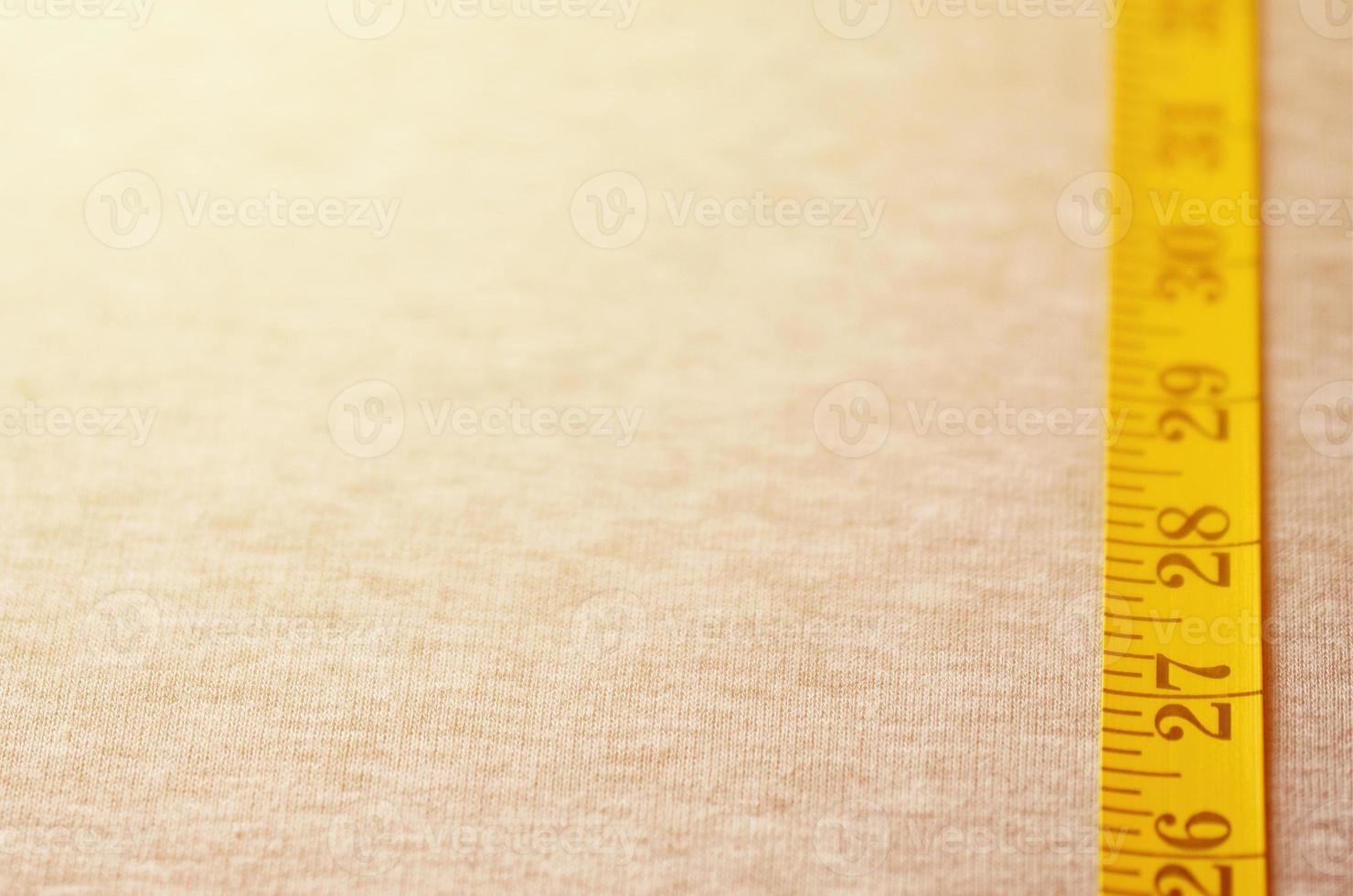la cinta métrica amarilla se encuentra sobre un tejido de punto gris foto