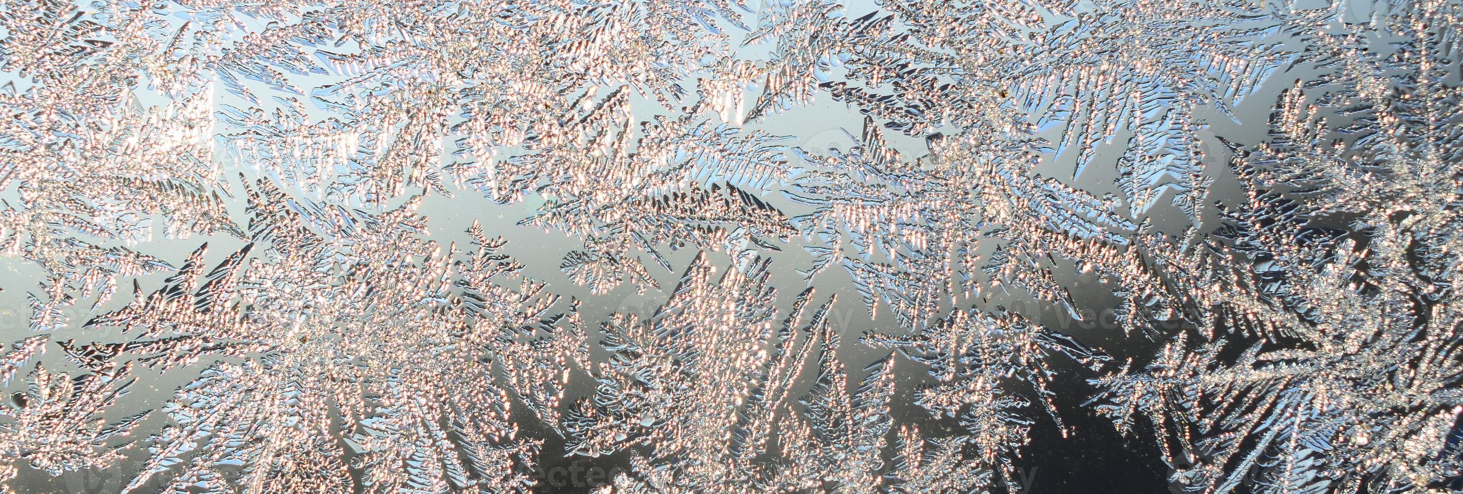 Snowflakes frost rime macro on window glass pane photo