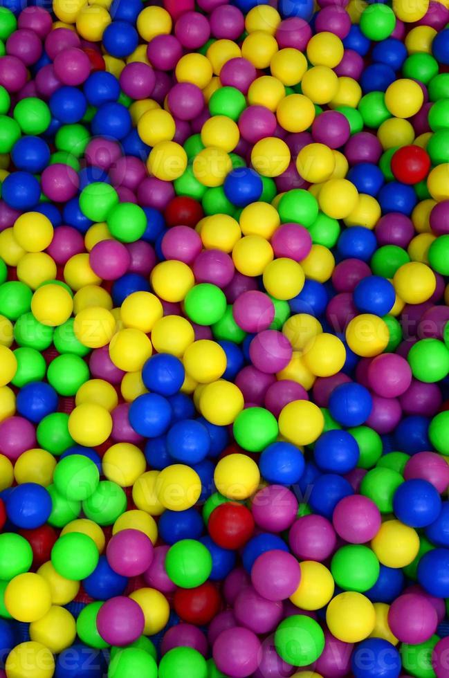 Many colorful plastic balls in a kids' ballpit at a playground. Close up pattern photo