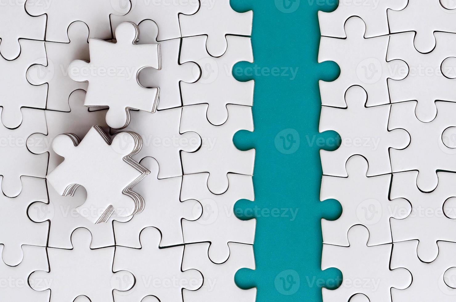 The blue path is laid on the platform of a white folded jigsaw puzzle. The missing elements of the puzzle are stacked nearby. Texture image with space for text photo