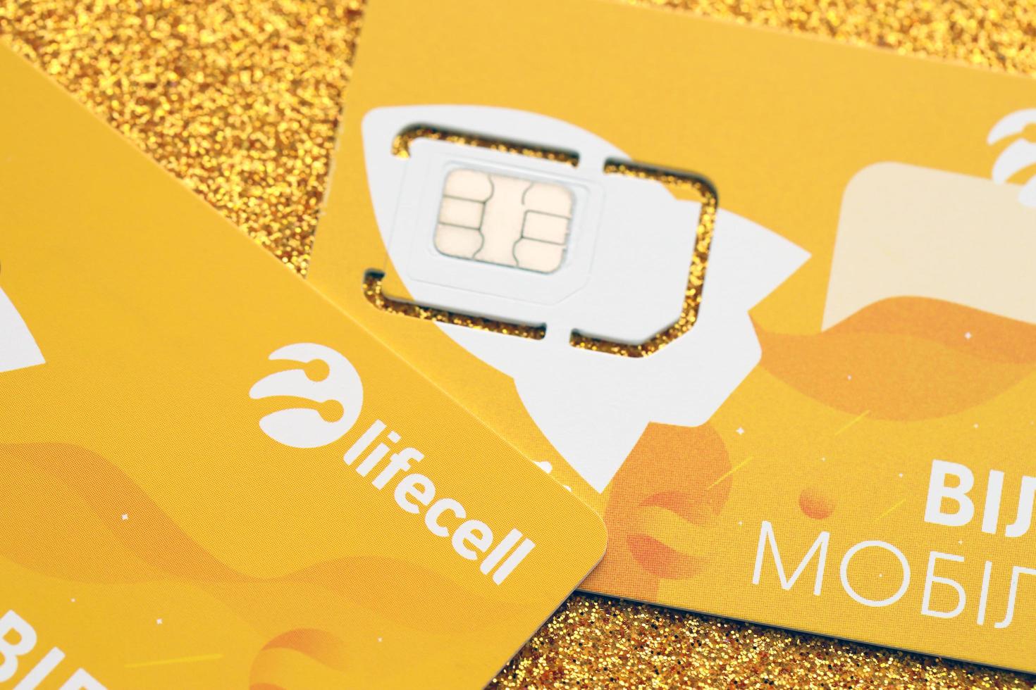 TERNOPIL, UKRAINE - JULY 5, 2022 Lifecell new sim card with free contract on yellow background. Lifecell is ukrainian mobile telephone network operator and provider of wireless connection photo