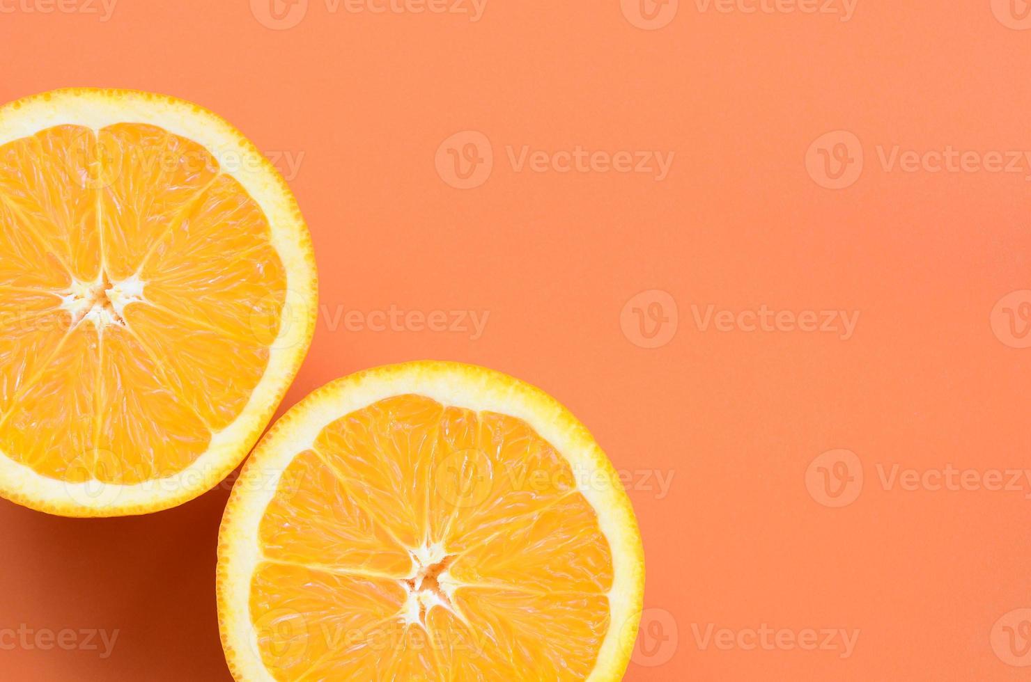 Top view of a several orange fruit slices on bright background in orange color. A saturated citrus texture image photo