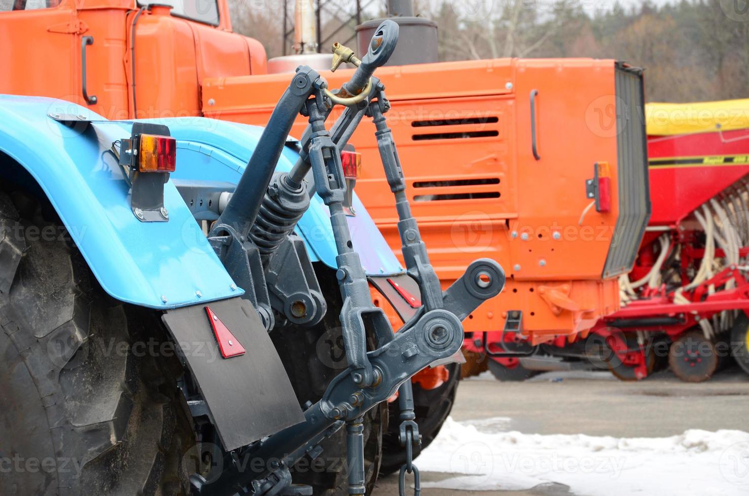 Wheels of back view of new tractor in snowy weather. Agricultural vehicle back view photo