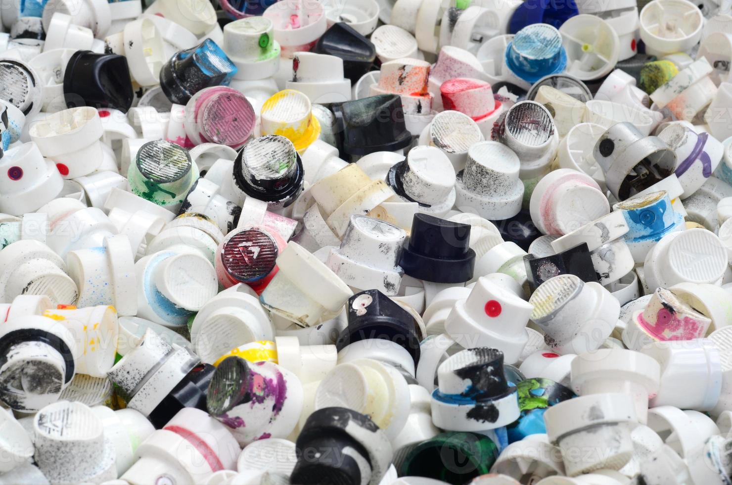 A pattern of many used and soiled nozzles from spray cans with aerosol paint. Background texture of the street art of drawing graffiti on the walls photo