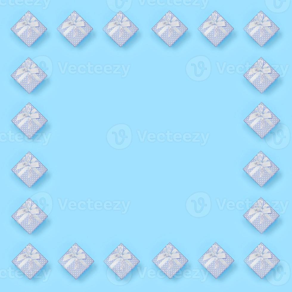 Frame of blue gift boxes lies on texture background of fashion pastel blue color paper in minimal concept photo