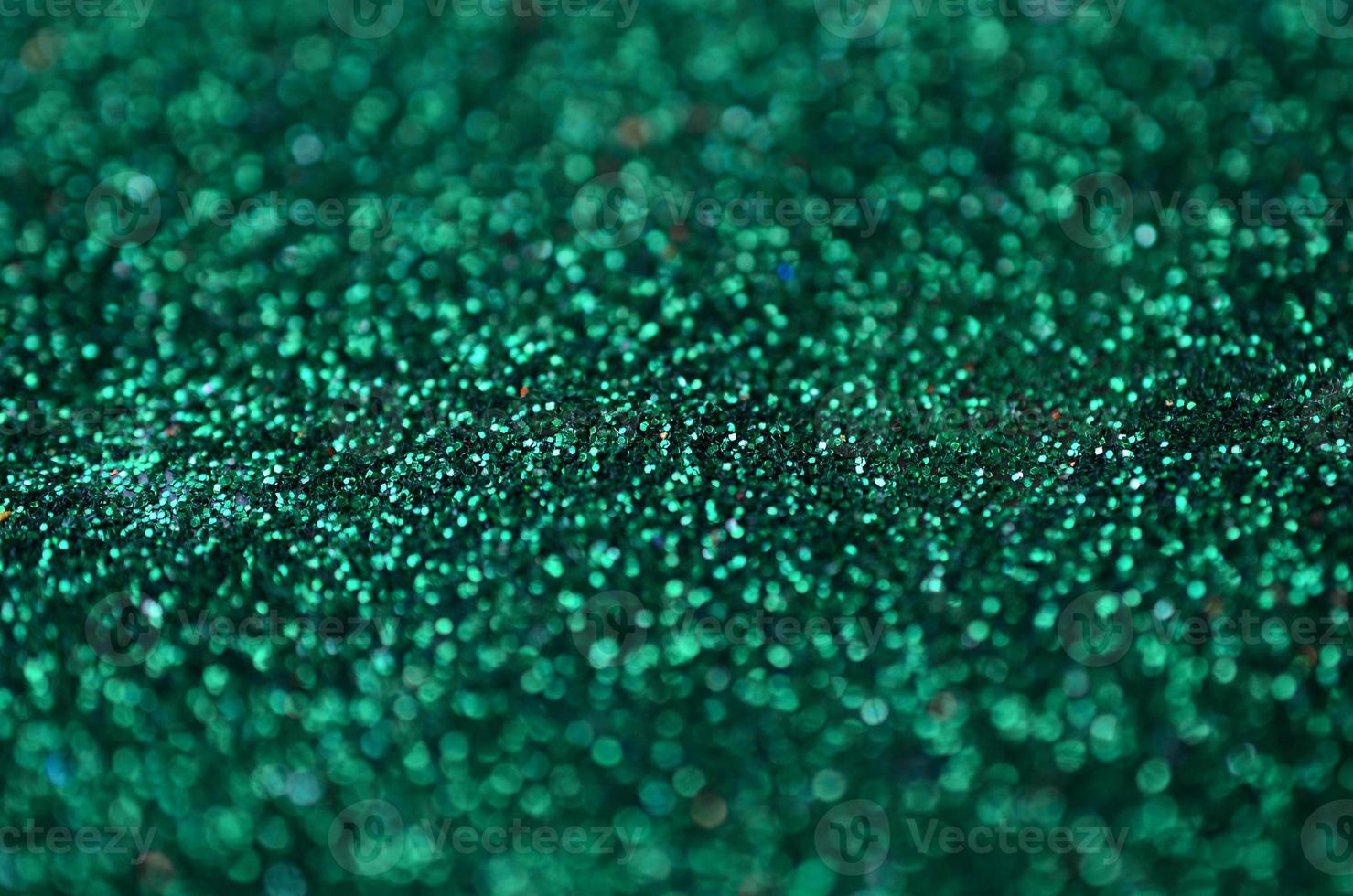 A huge amount of green decorative sequins. Background texture with shiny, small elements that reflect light in a random order. Glitter texture photo