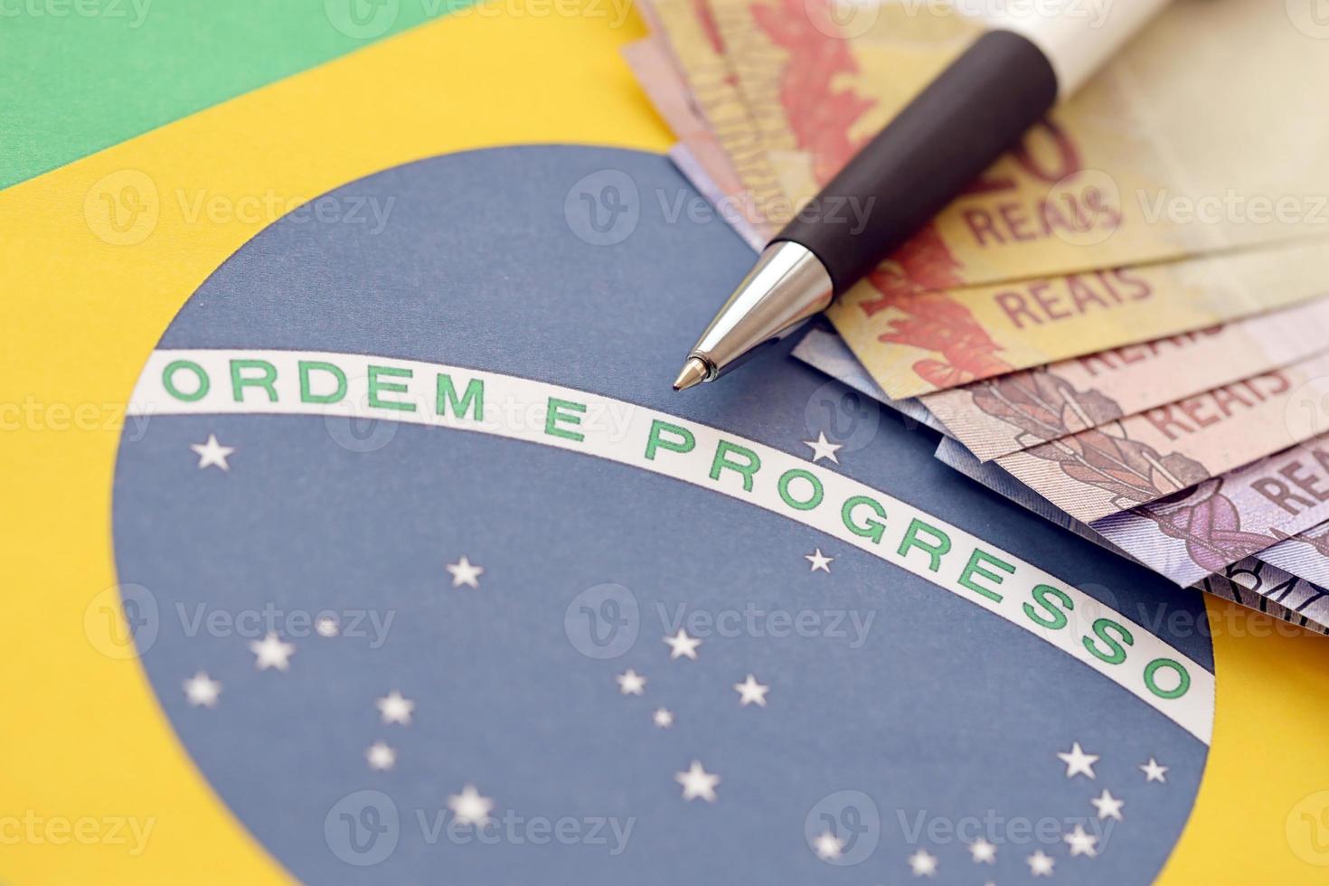 Pen with Brazilian money bills on blank of lottery game. Concept of luck and gambling in Brazil photo