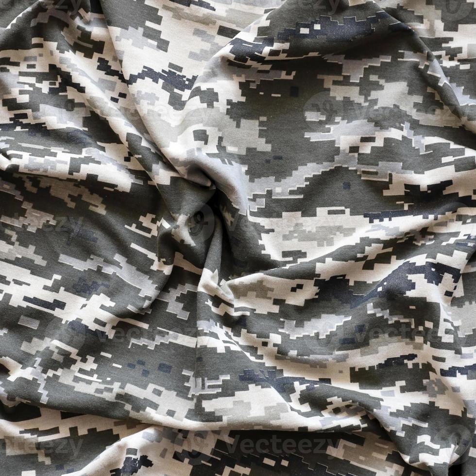 Fabric with texture of Ukrainian military pixeled camouflage. Cloth with camo pattern in grey, brown and green pixel shapes. Official uniform of Ukrainian soldiers photo