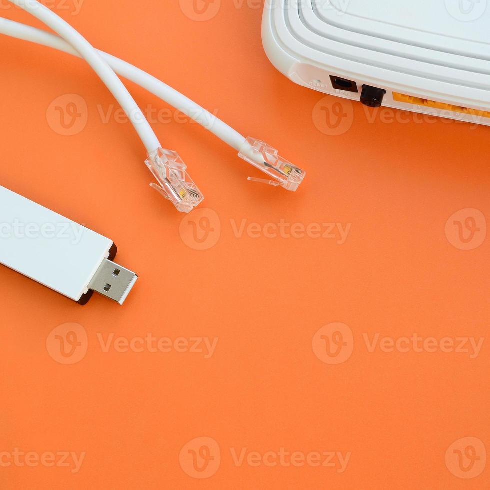 Internet router, portable USB wi-fi adapter and internet cable plugs lie on a bright orange background. Items required for internet connection photo
