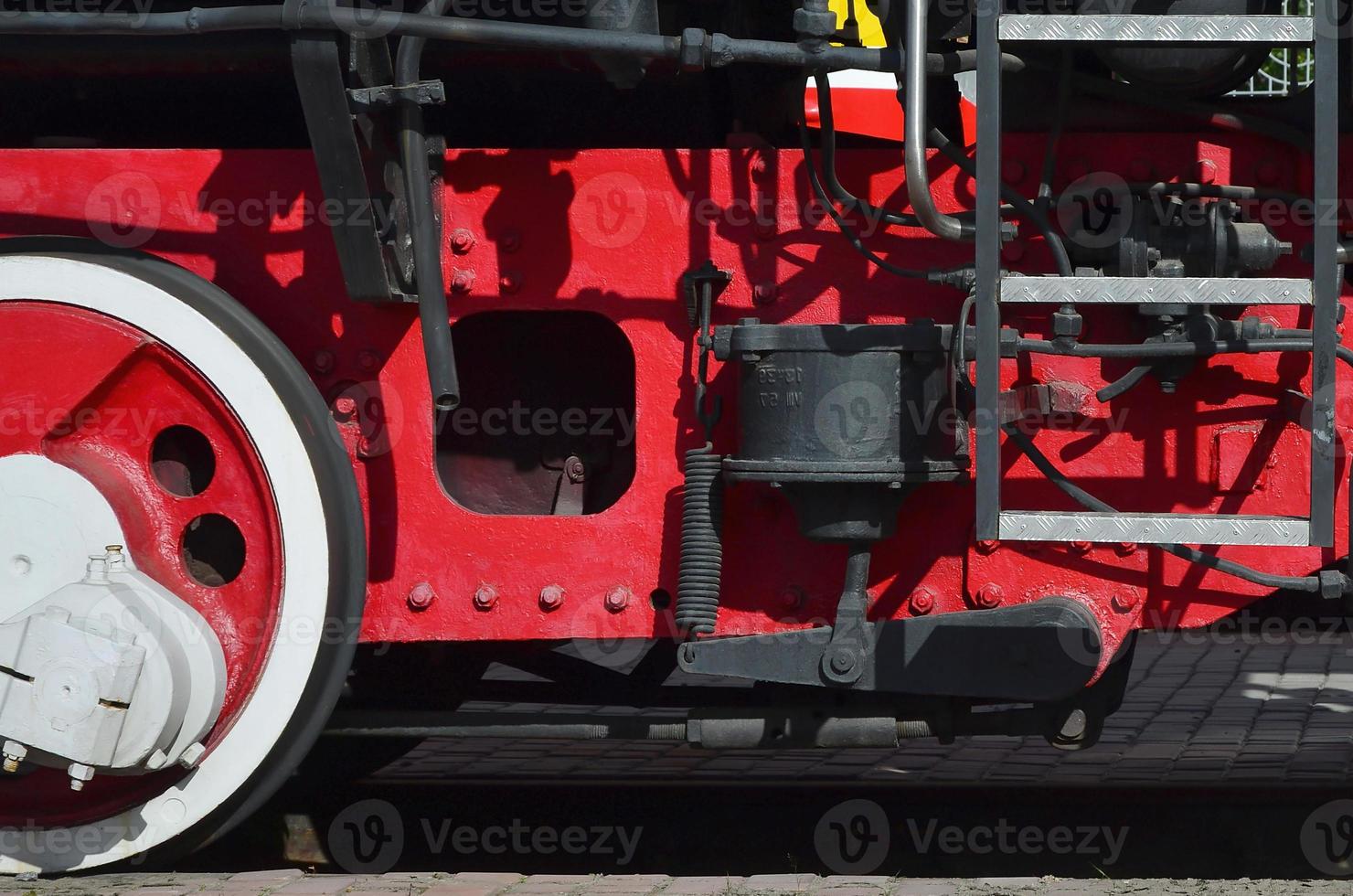 Wheels of the old black steam locomotive of Soviet times. The side of the locomotive with elements of the rotating technology of old trains photo