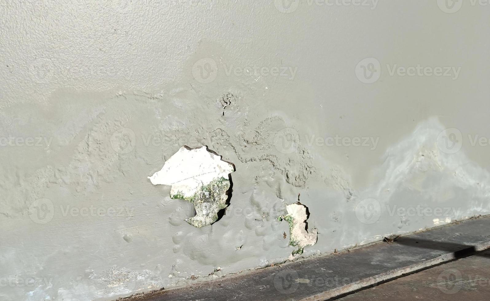 The walls of the old building are cracked, poorly repaired, with peeling paint. with copy space photo